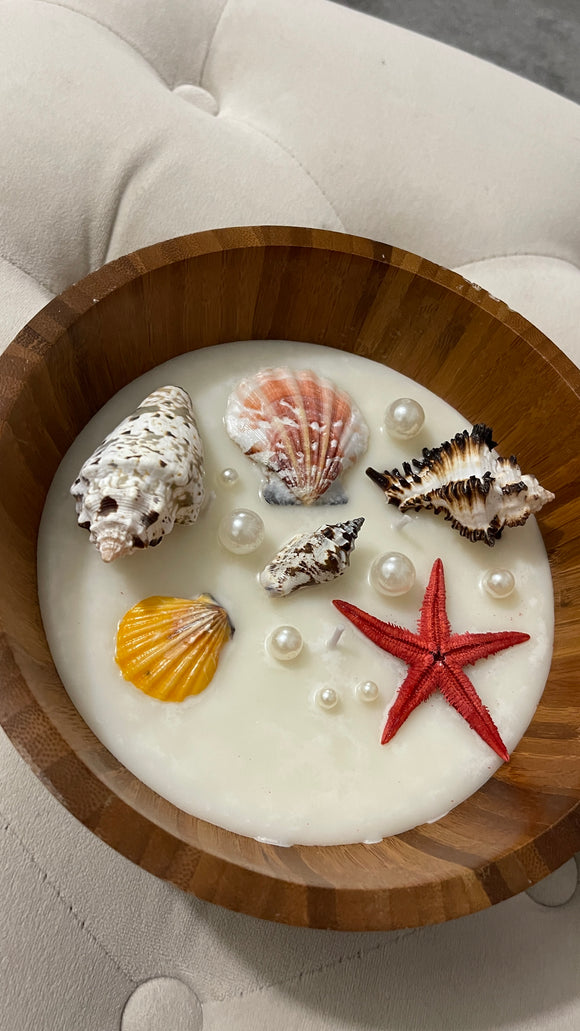 Seashell candle in a wooden bowl